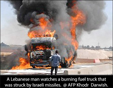 A Lebanese man watches a burning fuel truck