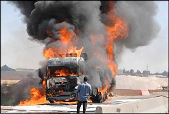 A Lebanese man watches a burning fuel truck